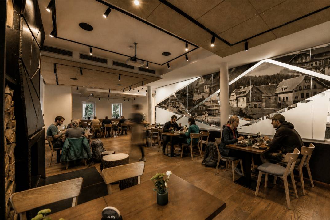 Interiér restaurace Horské chaty Smědava s návštěvníky po túře v Jizerských horách
