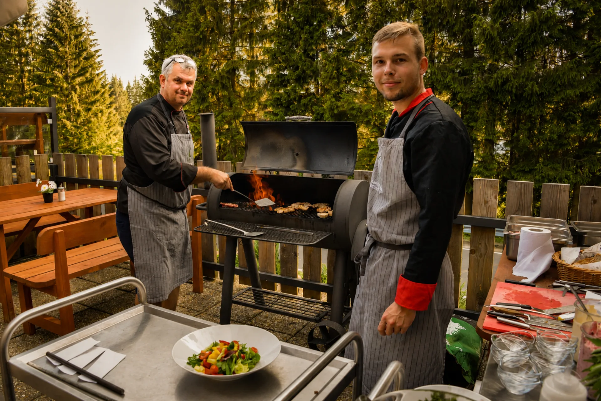 Kuchaři připravují grilované speciality na venkovní terase na Smědavě v Jizerských horách.